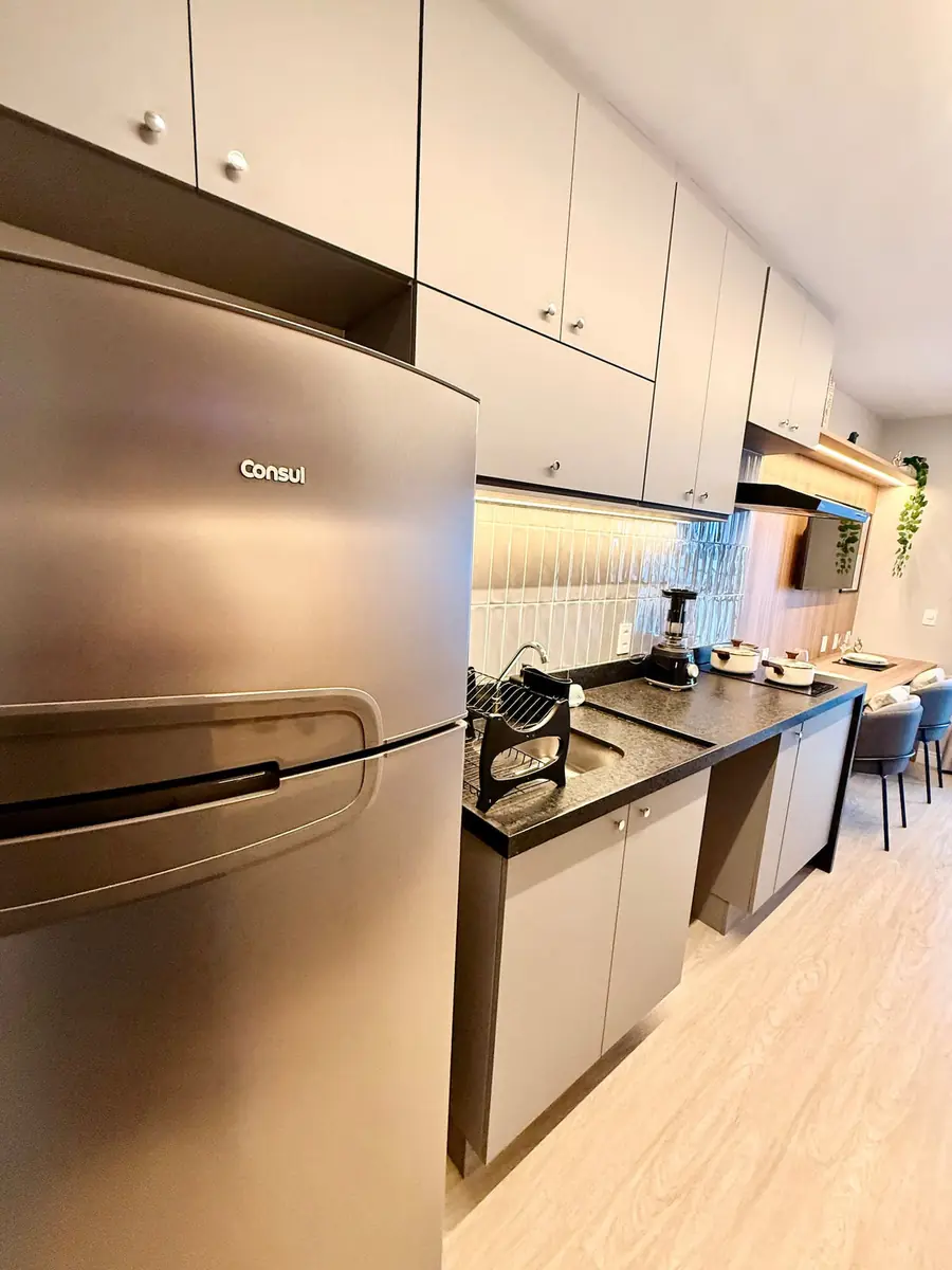 Cozinha com geladeira inox e cooktop